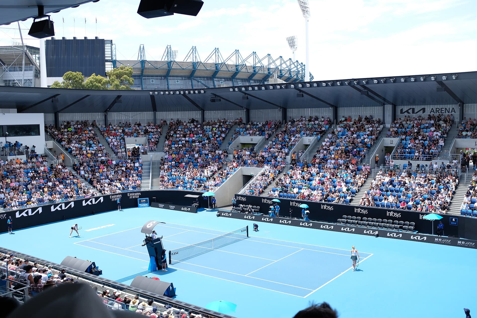 Bright blue tournament court inside the modern Kia Arena at Melbourne Park.