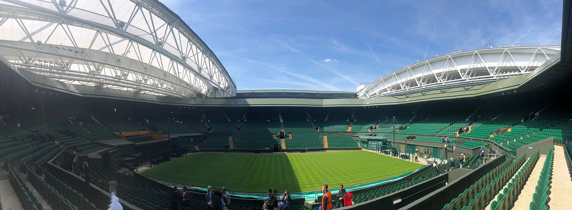 Panoramic view of the manicured grass and green stands at Wimbledon Centre Court.